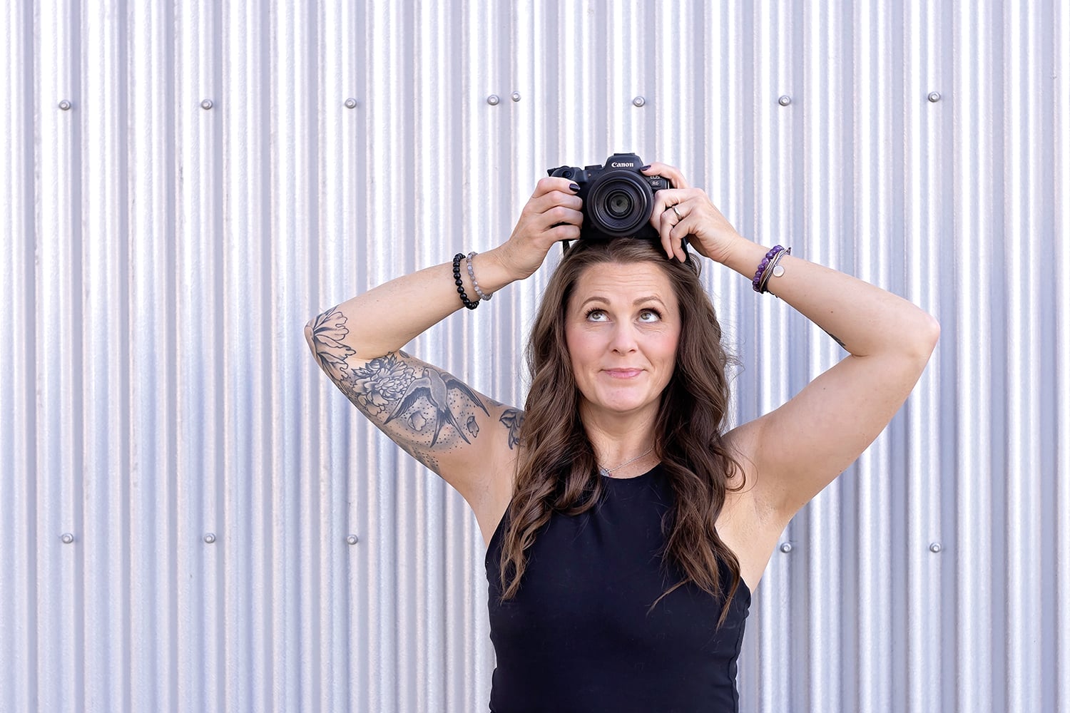 Female photographers holding a camera above her head